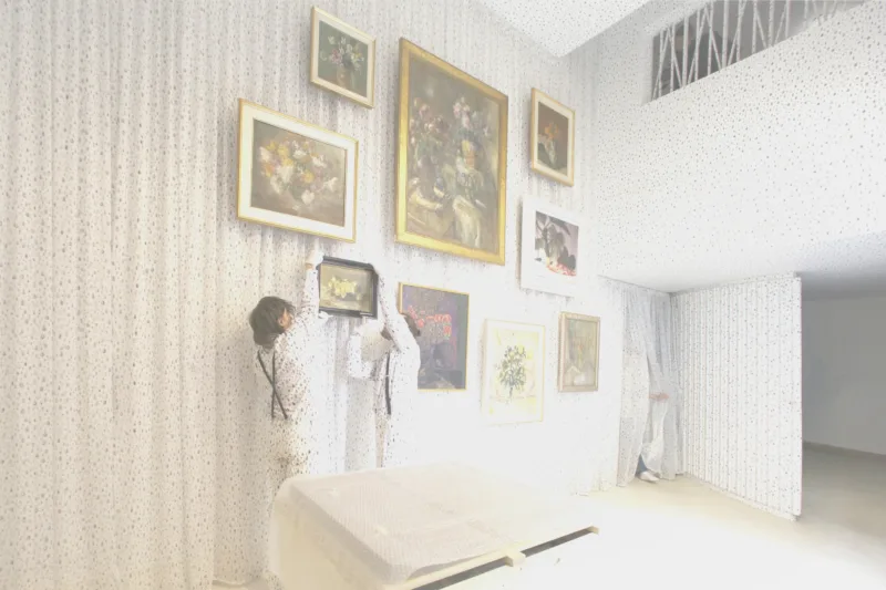 Installation view with performance We knew it would be hard to put anything on these walls, hanging of the painting by Ivana Kobilca (Rožeteje, sine anno), For Our Economy and Culture, Pavilion of Slovenia, Venice Biennial